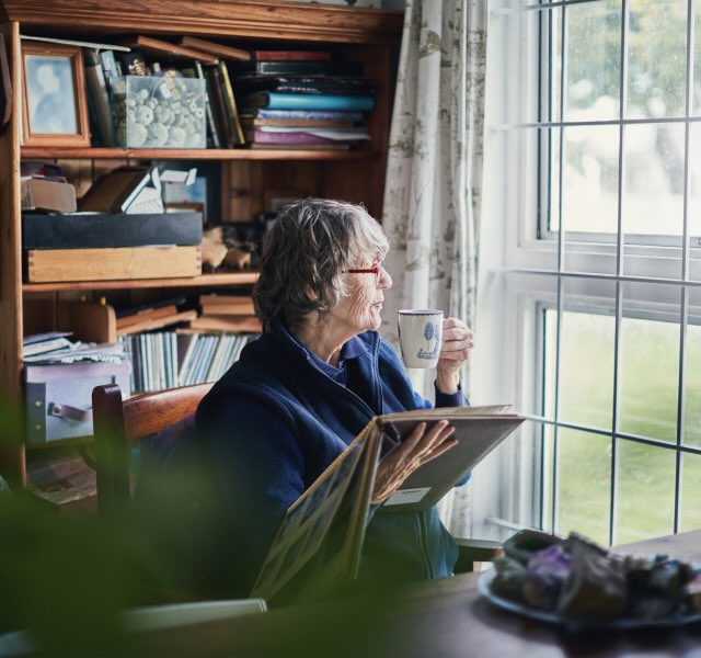 woman looking out window reflecting